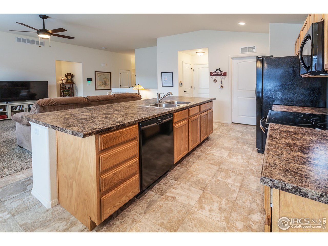 944 Maplebrook Drive Windsor, CO 80550 - Photo 13 of 32 a kitchen with stainless steel appliances granite countertop a sink stove and refrigerator
