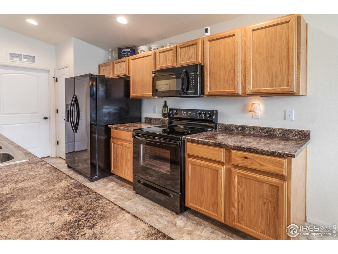 944 Maplebrook Drive Windsor, CO 80550 - Photo 16 of 32 a kitchen with stainless steel appliances granite countertop a stove a refrigerator and a microwave
