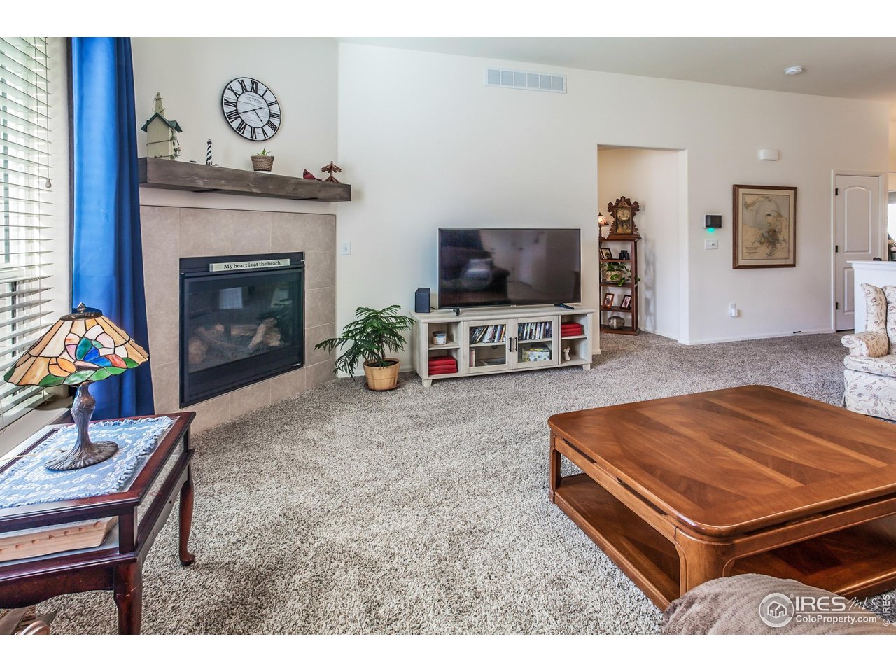 944 Maplebrook Drive Windsor, CO 80550 - Photo 9 of 32 a living room with furniture a flat screen tv and a fireplace