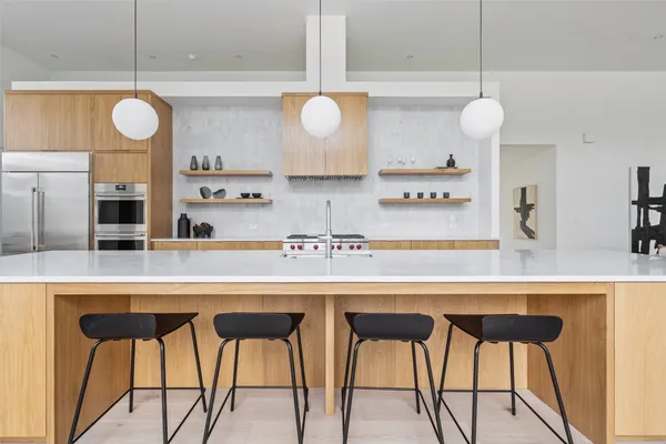 a kitchen with stainless steel appliances kitchen island granite countertop a table and chairs in it