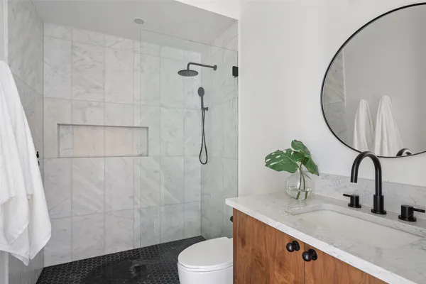 a bathroom with a granite countertop sink toilet and shower