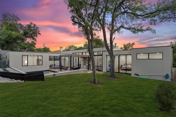 a view of a house with a yard and a tree