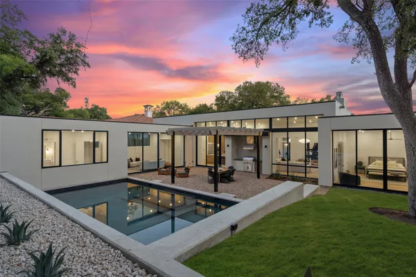 a view of a house with pool and chairs