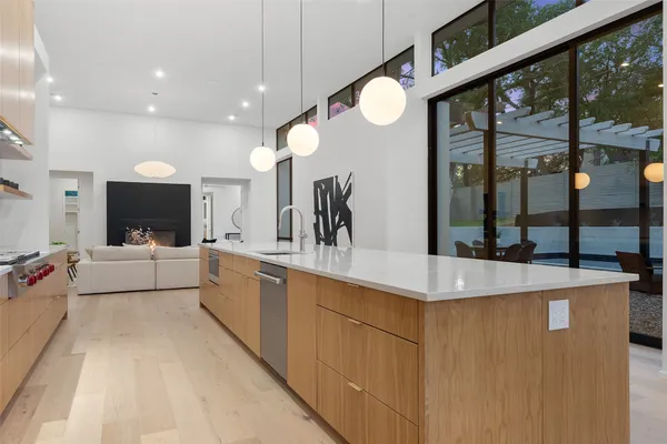 a large white kitchen with a large window and stainless steel appliances