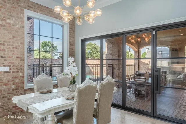 a view of a dining room with furniture large windows and chandelier