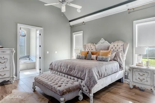 a bedroom with a bed a ceiling fan and a dresser