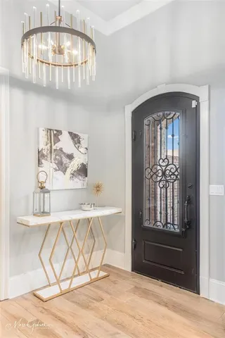 a view of a livingroom with wooden floor and a chandelier