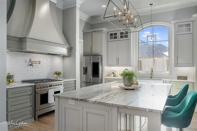 a kitchen with stainless steel appliances granite countertop a sink a stove and cabinets
