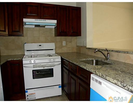 821 Edpas Road New Brunswick, NJ 08901 - Photo 7 of 12 a kitchen with granite countertop cabinets stainless steel appliances and a counter space