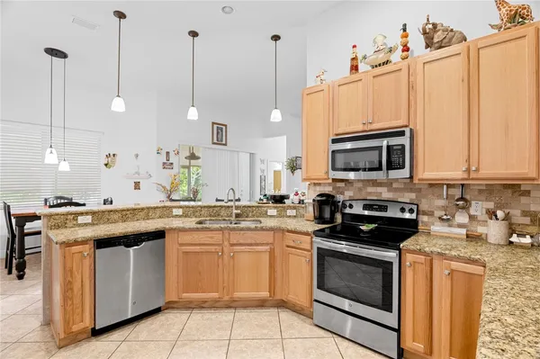 a kitchen with granite countertop a sink and a chandelier