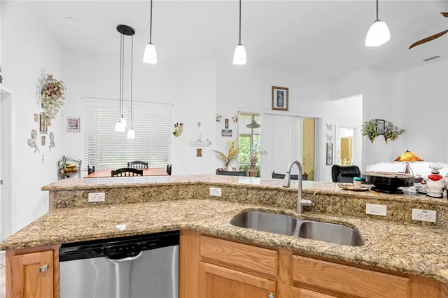 a view of a dining room and livingroom with furniture wooden floor a chandelier and a painting