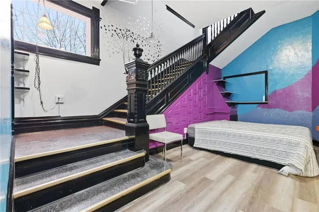 a bedroom with bed and wooden floor