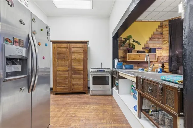 a kitchen with stainless steel appliances granite countertop a refrigerator a oven and a stove