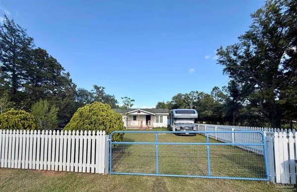 a view of a house with a wooden deck and a yard