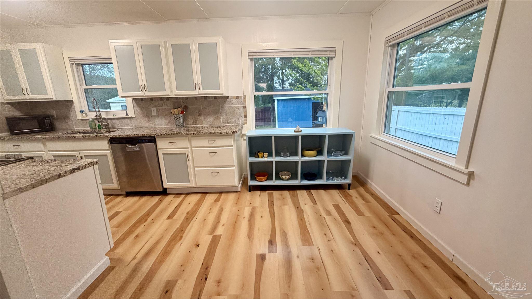 8816 Gibson Road Molino, FL 32577 - Photo 19 of 61 a kitchen with wooden floors and windows