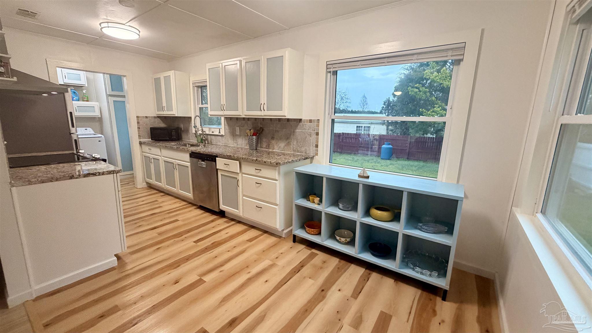 8816 Gibson Road Molino, FL 32577 - Photo 22 of 61 a kitchen with stainless steel appliances a stove top oven a sink a refrigerator and cabinets