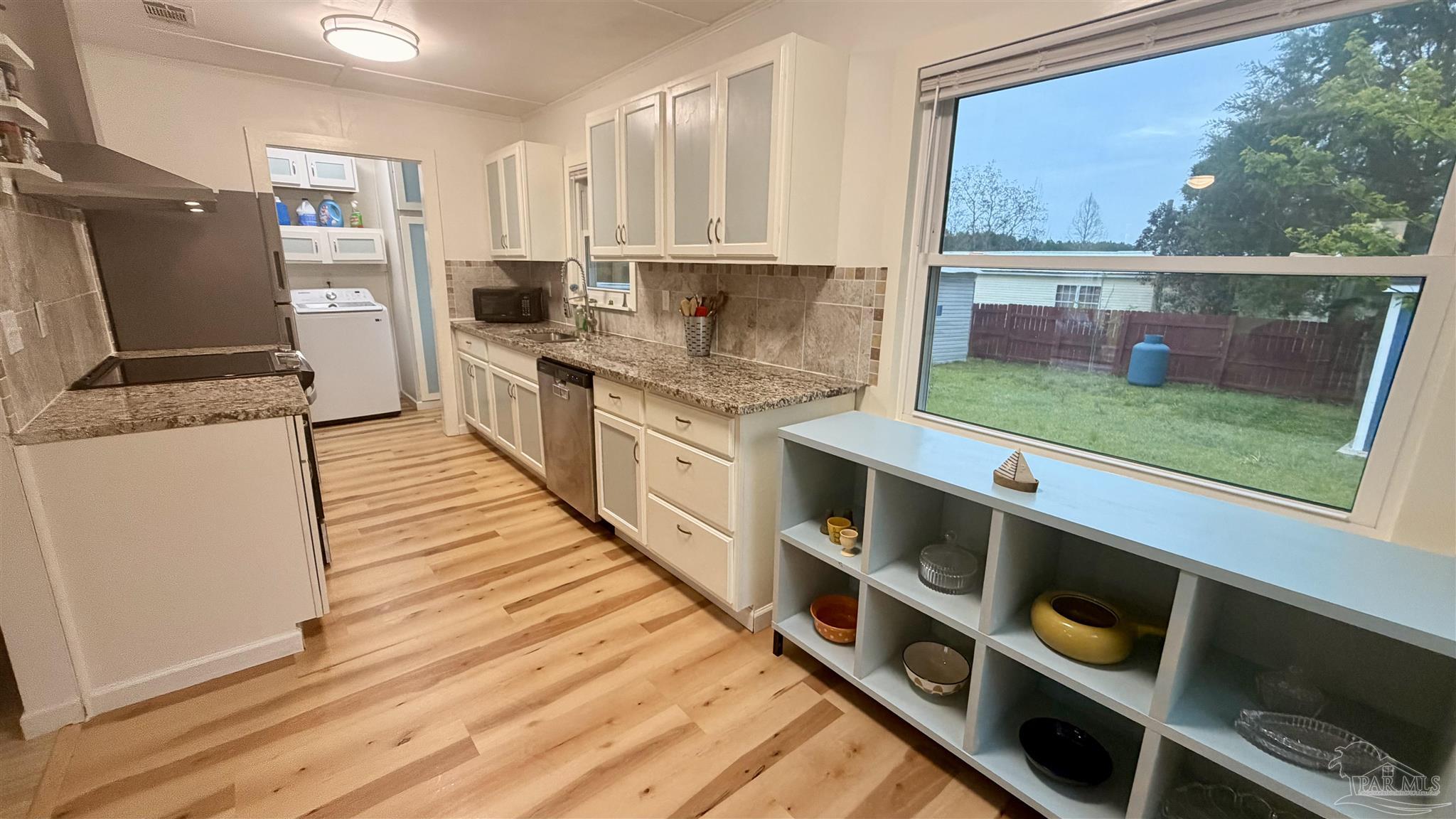 8816 Gibson Road Molino, FL 32577 - Photo 24 of 61 a kitchen with stainless steel appliances granite countertop a refrigerator a stove and a sink with wooden floor