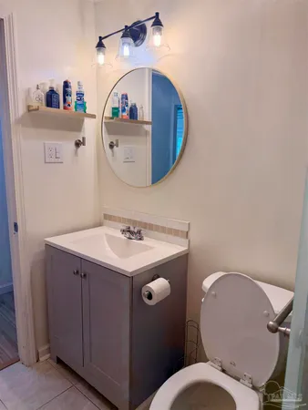 a view of a hallway with wooden floor and a bathroom