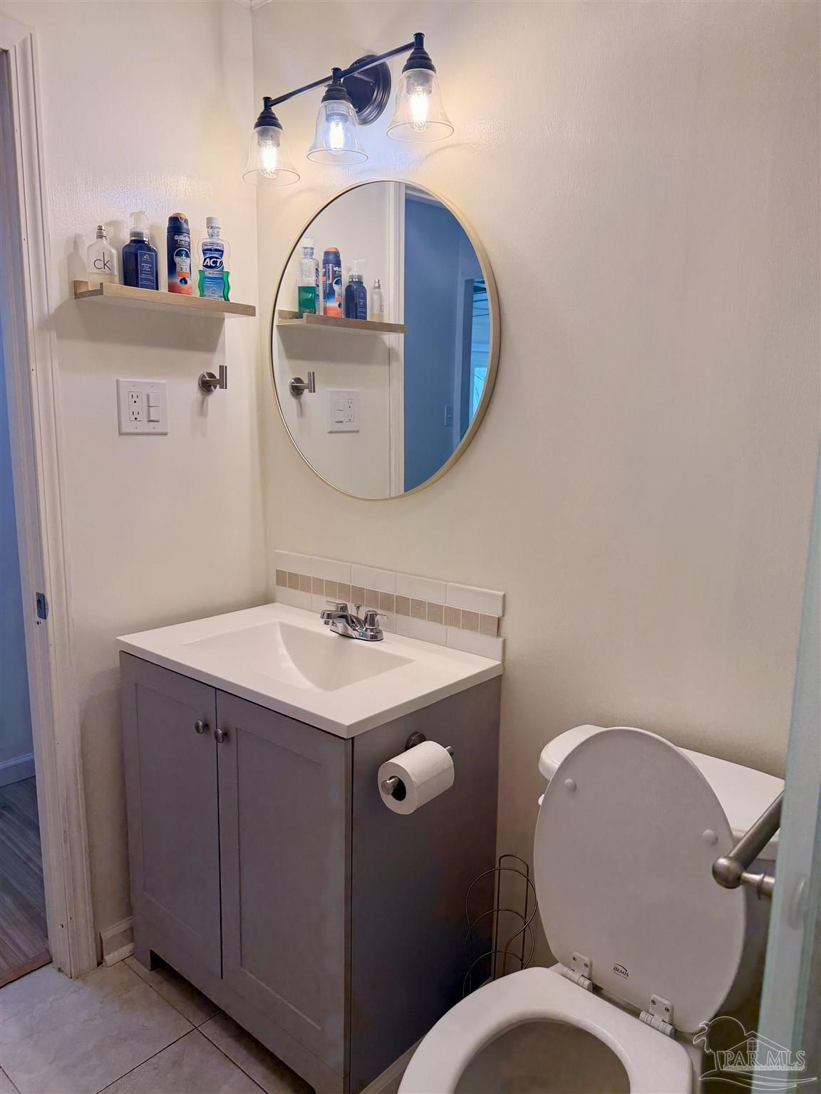 8816 Gibson Road Molino, FL 32577 - Photo 28 of 61 a bathroom with a toilet a sink and a mirror