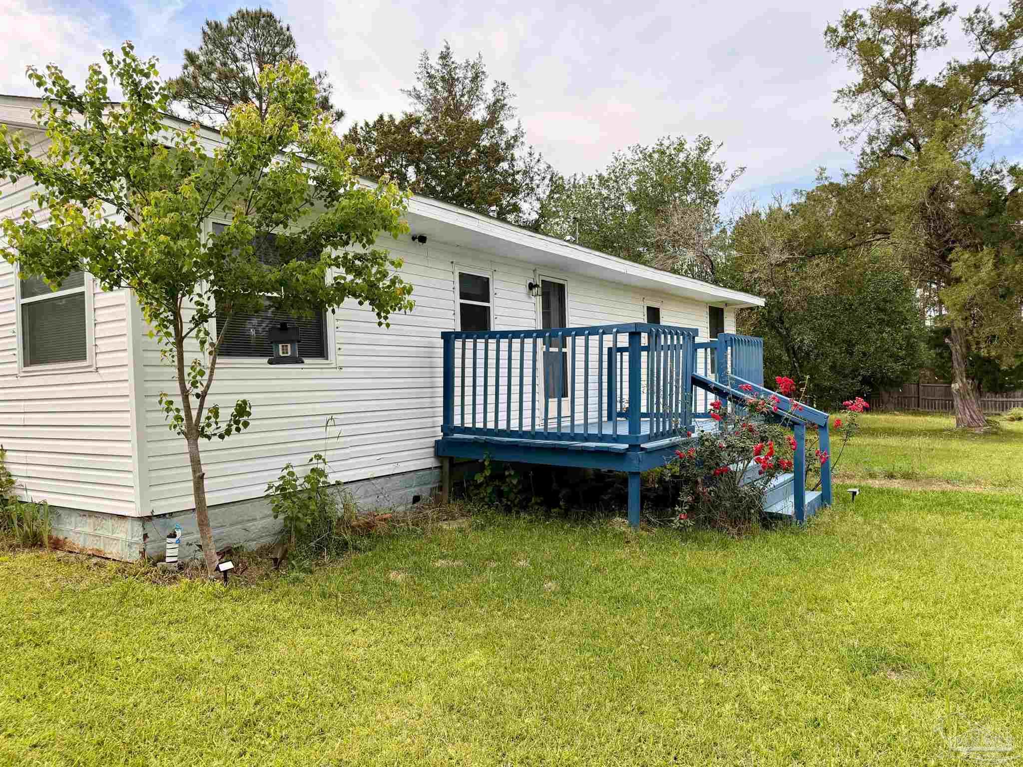 8816 Gibson Road Molino, FL 32577 - Photo 9 of 61 a view of a house with a wooden deck and a yard
