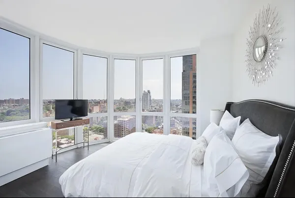 a bedroom with a bed and large window