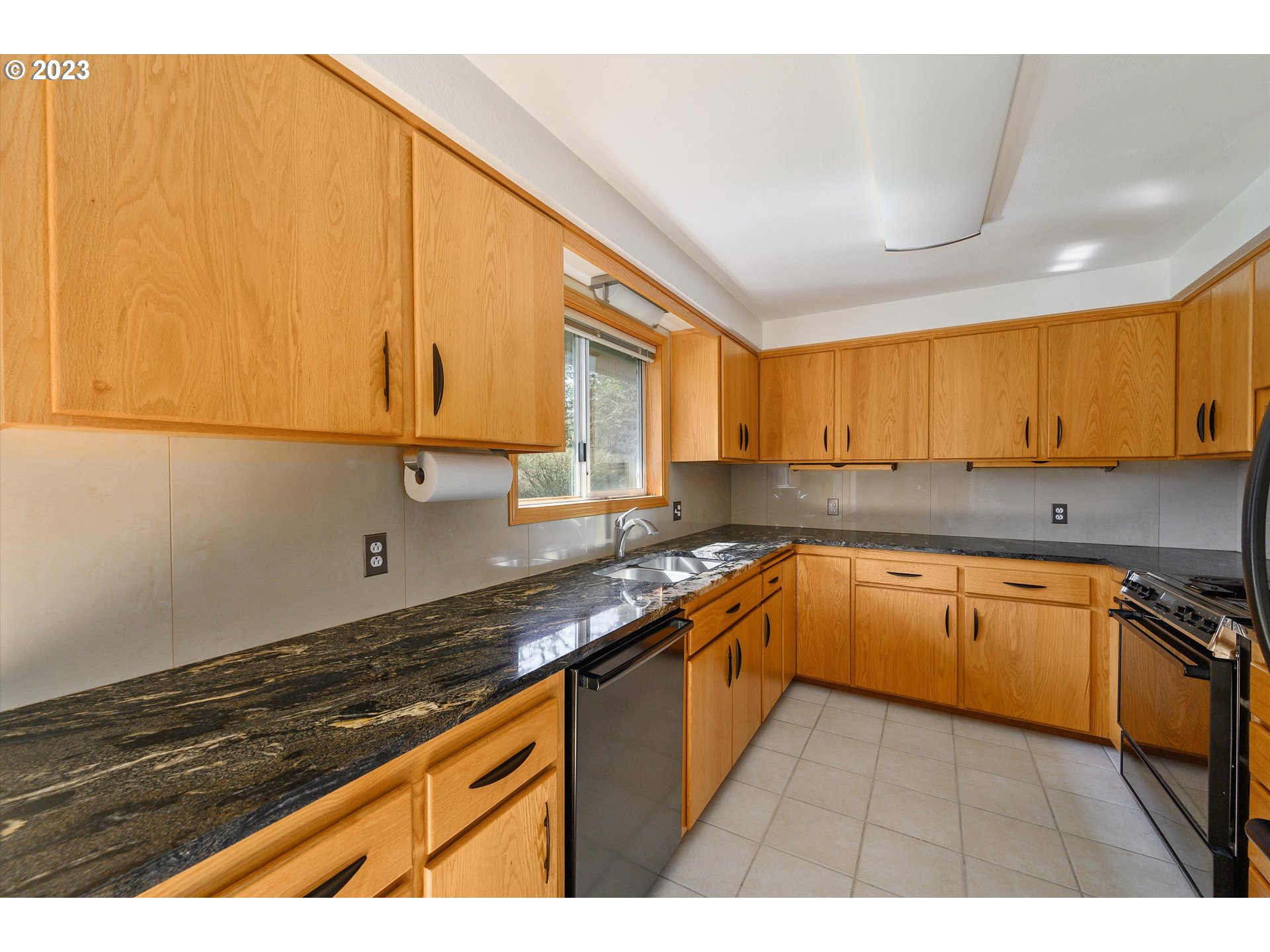 15775 Oakdale Road Dallas, OR 97338 - Photo 11 of 32 a kitchen with granite countertop a sink stove and cabinets