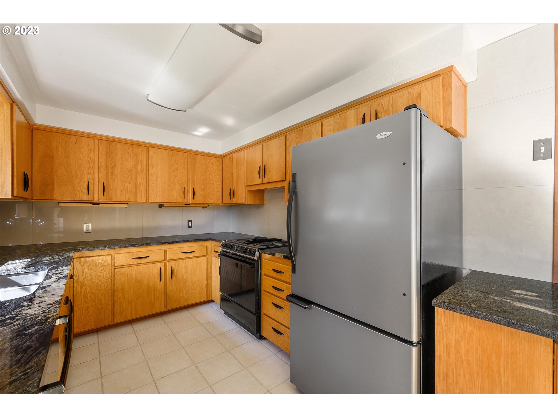15775 Oakdale Road Dallas, OR 97338 - Photo 12 of 32 a kitchen with stainless steel appliances granite countertop a refrigerator a sink dishwasher a stove with wooden cabinets