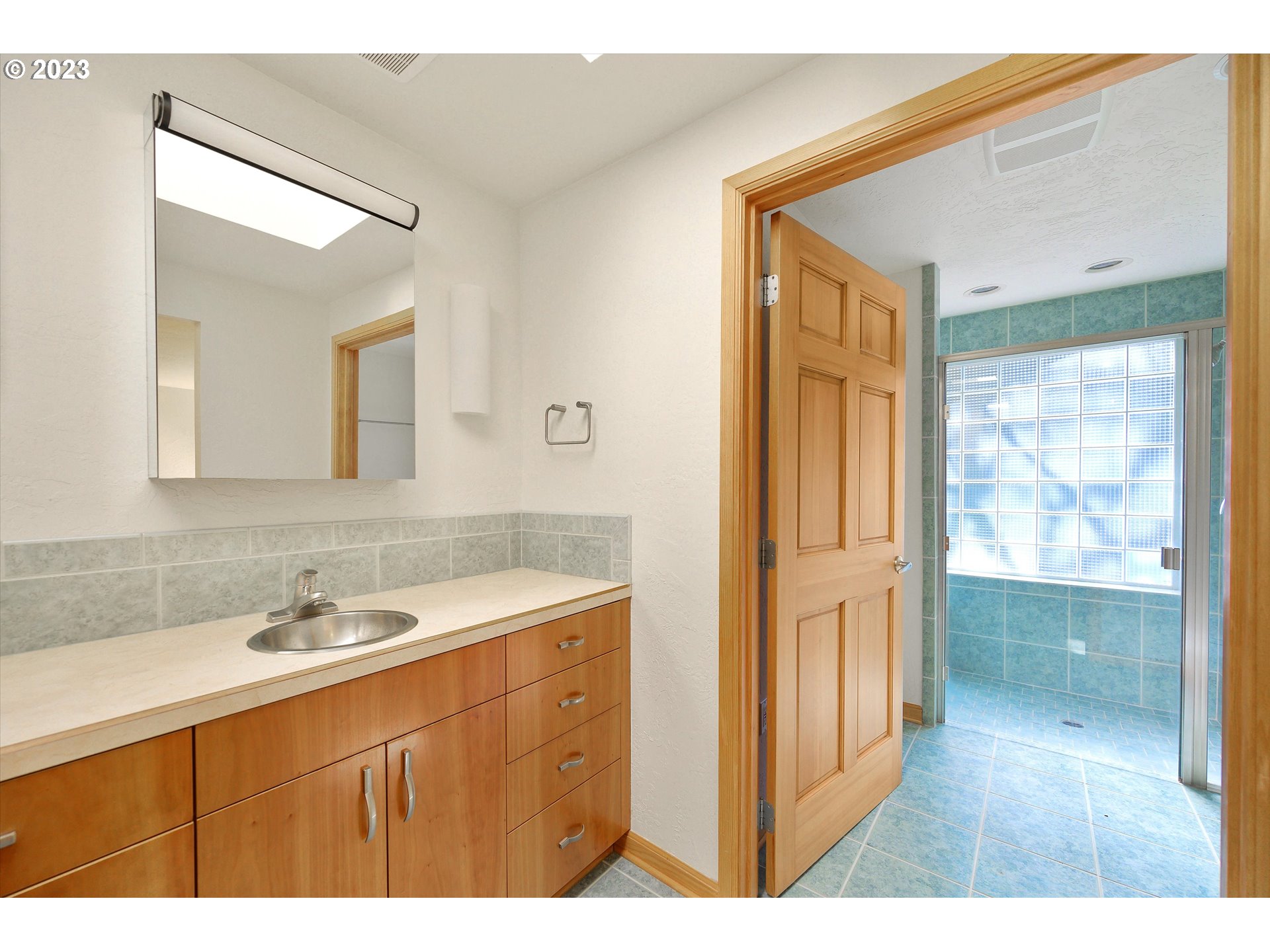 15775 Oakdale Road Dallas, OR 97338 - Photo 19 of 32 a bathroom with a sink a mirror and a shower
