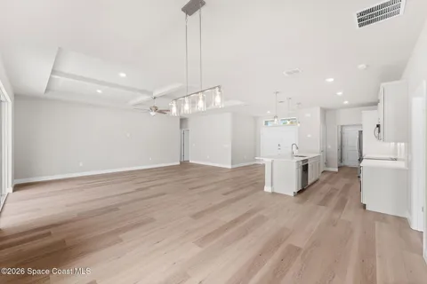 a view of empty room with wooden floor and window
