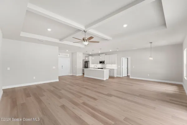 a view of empty room with wooden floor and window