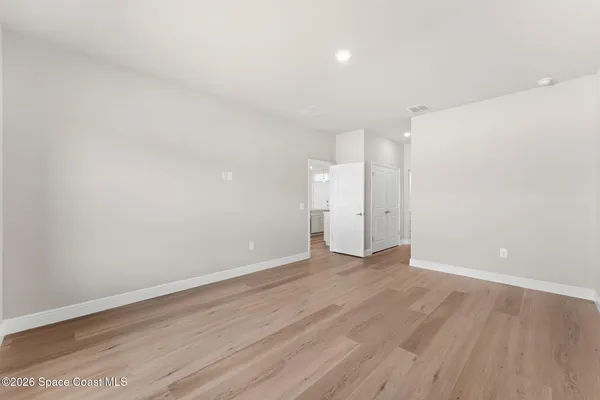 a view of an empty room with wooden floor