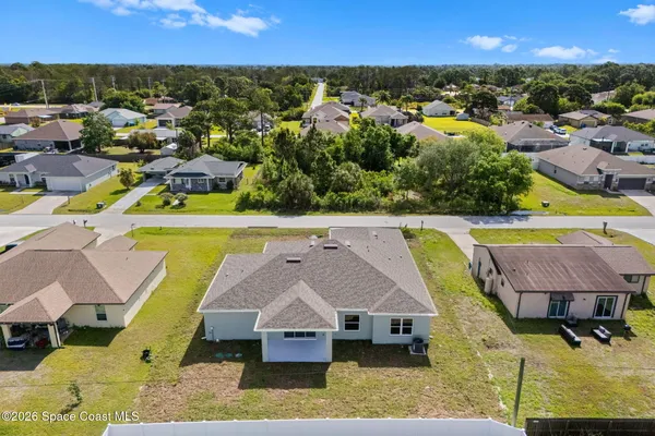 an aerial view of residential houses with outdoor space and swimming pool