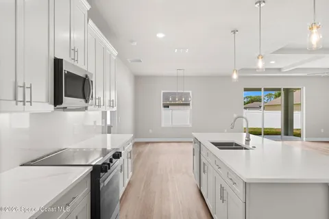 a large kitchen with kitchen island a refrigerator a sink and a stove