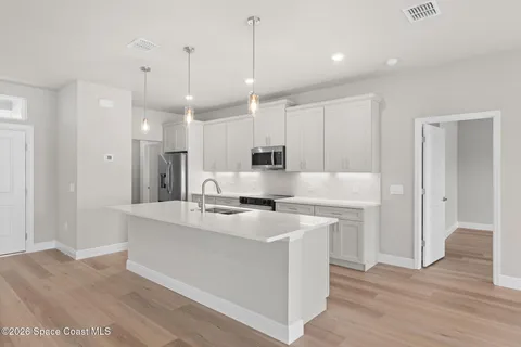 a view of a kitchen with a sink and a refrigerator