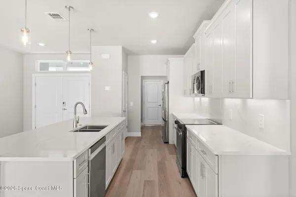 a kitchen with a sink a counter top space stainless steel appliances and cabinets