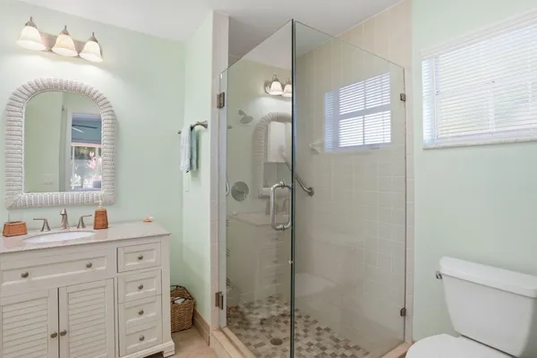 a bathroom with a sink a toilet and shower