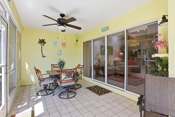 a outdoor space with lots of chairs a chandelier and a glass door