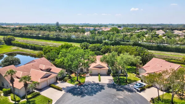 an aerial view of a house with a garden and lake view