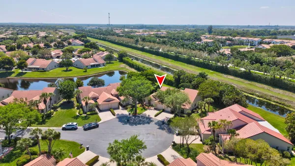 an aerial view of a house with a garden and lake view