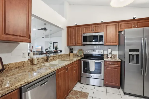a kitchen with stainless steel appliances granite countertop a sink stove and refrigerator