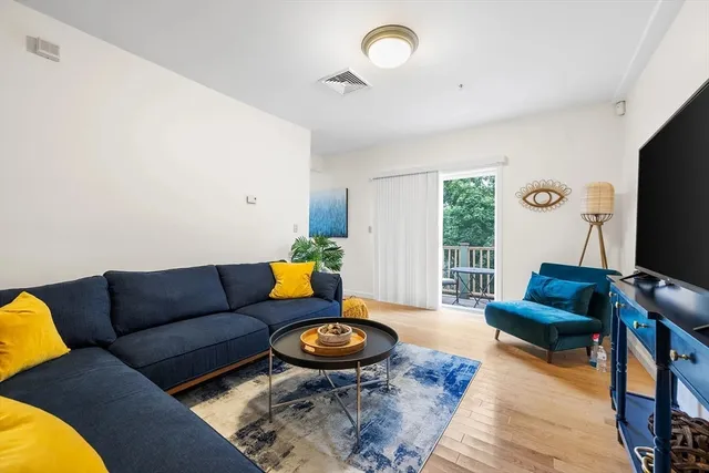 a living room with furniture a rug and a flat screen tv