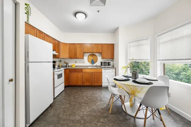 a kitchen with a table chairs stove and refrigerator
