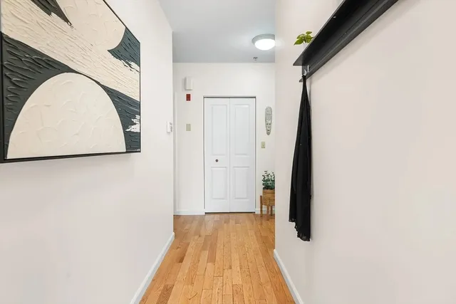a view of a hallway with wooden floor and staircase