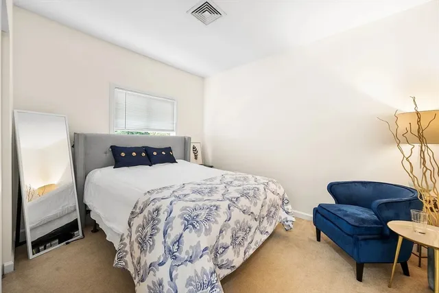 a bedroom with a bed couch and a window