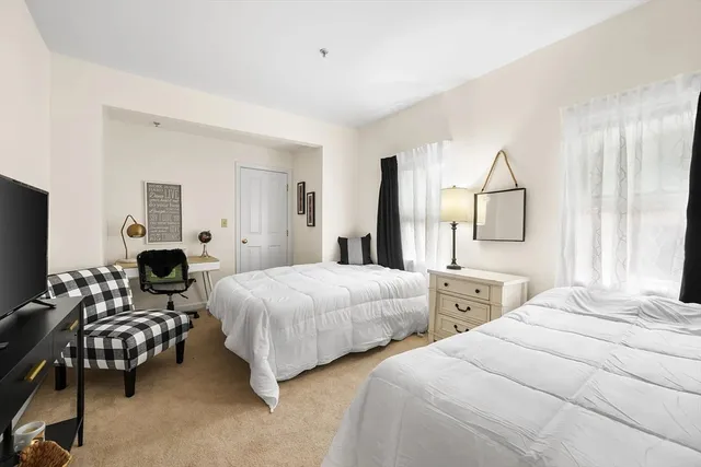 a bedroom with two beds and a large mirror with a dresser