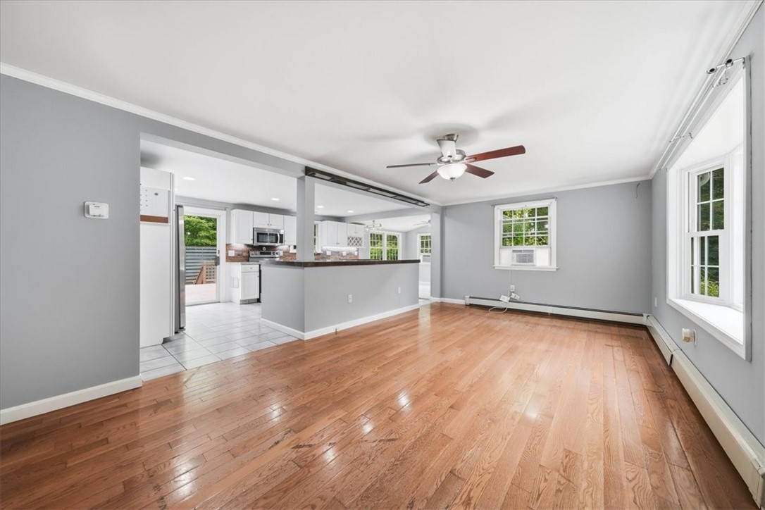 214 Anan Wade Road Glocester, RI 02857 - Photo 10 of 50 The spacious living room welcomes you with gleaming hardwood floors, abundant natural light, crown molding, and a ceiling fan.