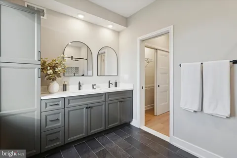 a spacious bathroom with a double vanity sink and mirror