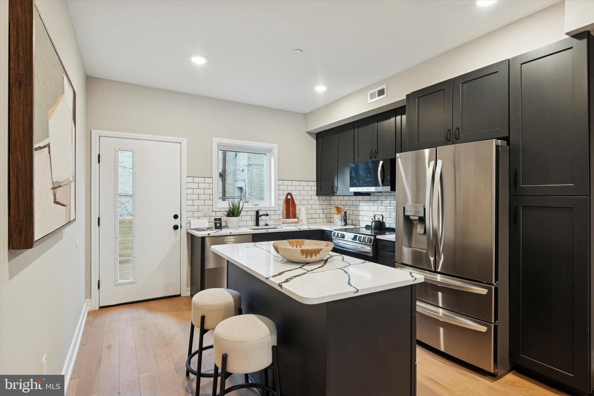 1620 North Randolph Street Philadelphia, PA 19122 - Photo 6 of 25 a kitchen with kitchen island a refrigerator stove and sink