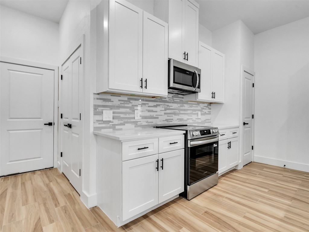 4421 Reed Road, Unit A AND B Houston, TX 77051 - Photo 6 of 27 a kitchen with stainless steel appliances white cabinets and a stove top oven