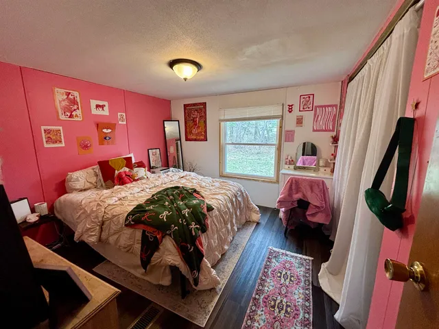 a bed sitting in a bedroom next to a window